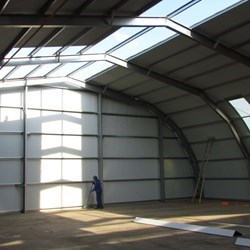 Vista interna do hangar de aço quase terminado, muito espaçoso, o homem la atras é uma referência para a altura do edifício: 6,7m.