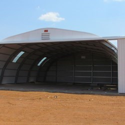 Vista frontal da Frisomat Omega + com um vão de 18m e uma porta XXL de 15m de largura e 5m de altura, com a porta aberta.