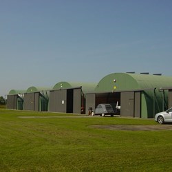 row of 5 round roofed omegas facing the runway on an airfield
