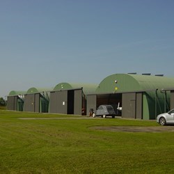 row of 5 round roofed omegas facing the runway on an airfield