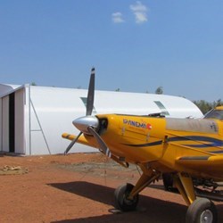 Lateral view of the Frisomat Omega+ airplane hangar with in the front the Embraer Ipanema agricultural plane.
