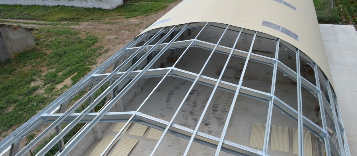 Omega+ em cima de uma parede de contenção, detalhe da estrutura metálica do telhado redondo